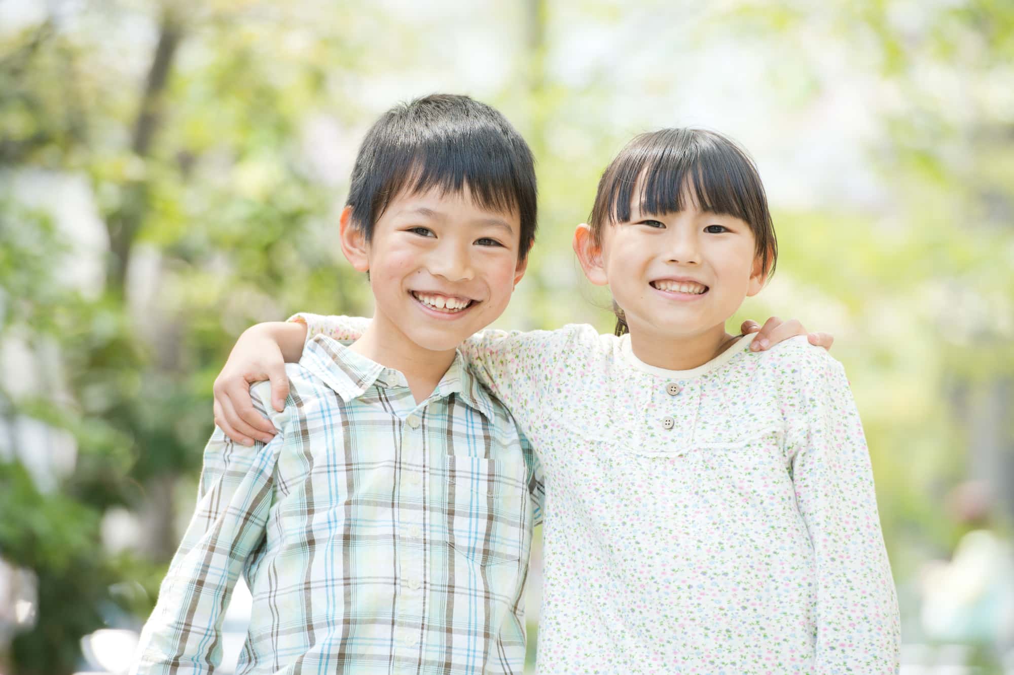 2人の子どもが仲良く肩を組んでいるイメージ