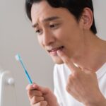 歯周病かと歯茎を気にする男性