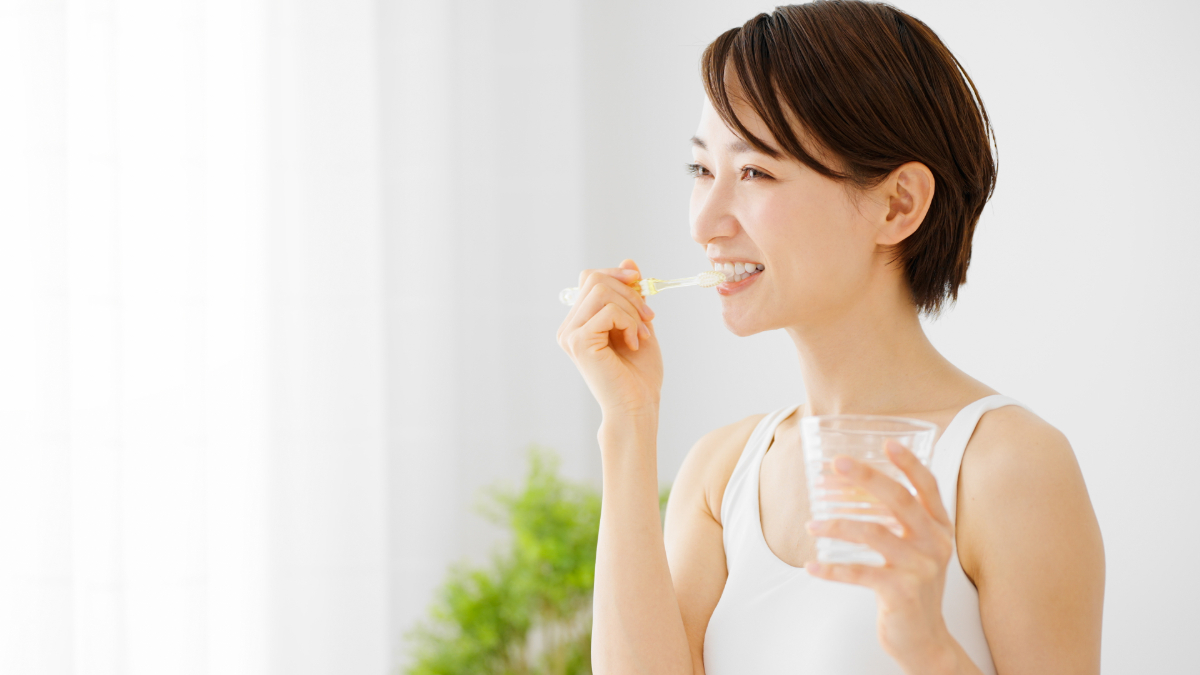 マウスピース矯正治療中に歯磨きケアする女性