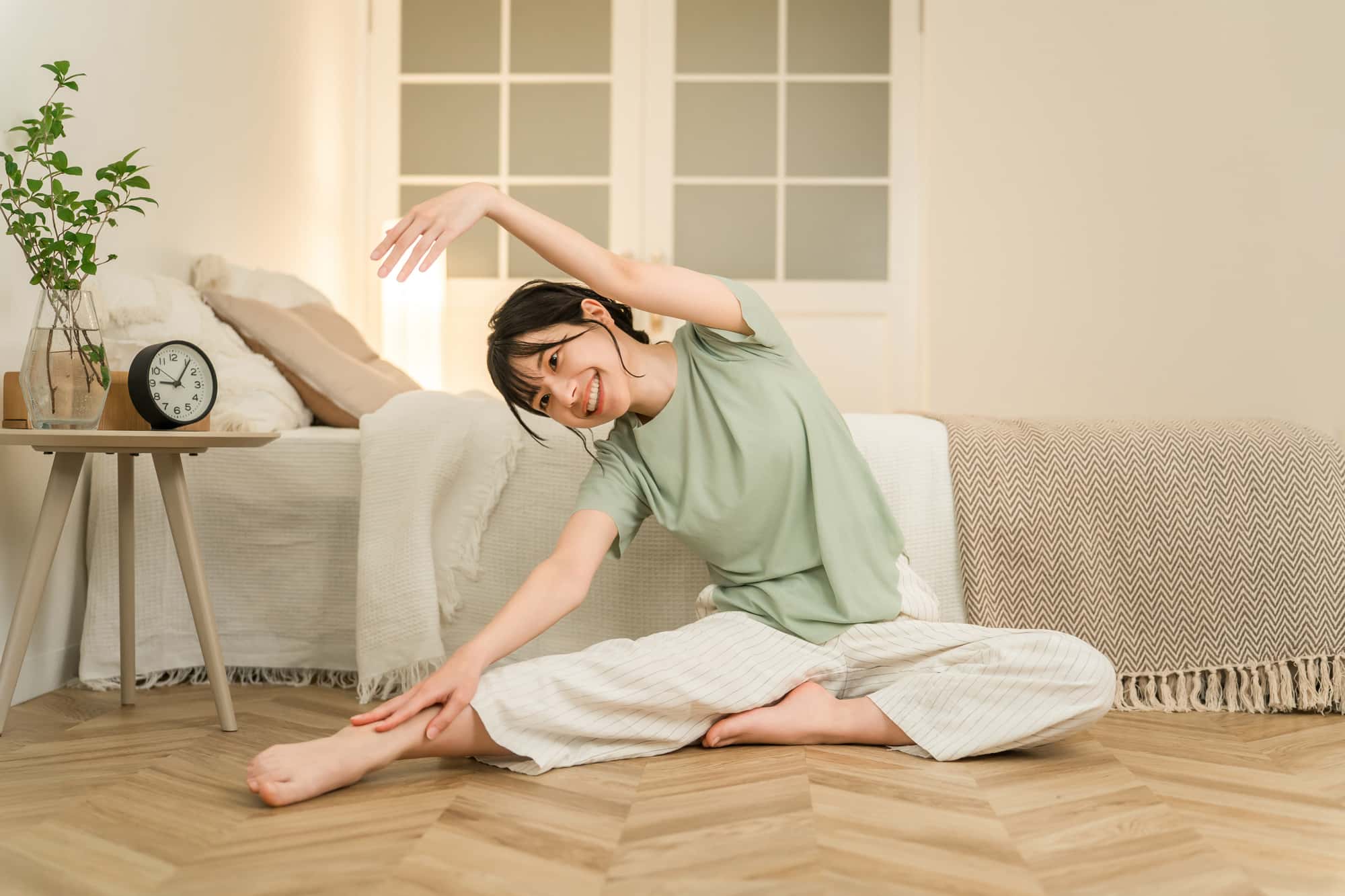 歯ぎしり対策で就寝前に軽いストレッチをする女性